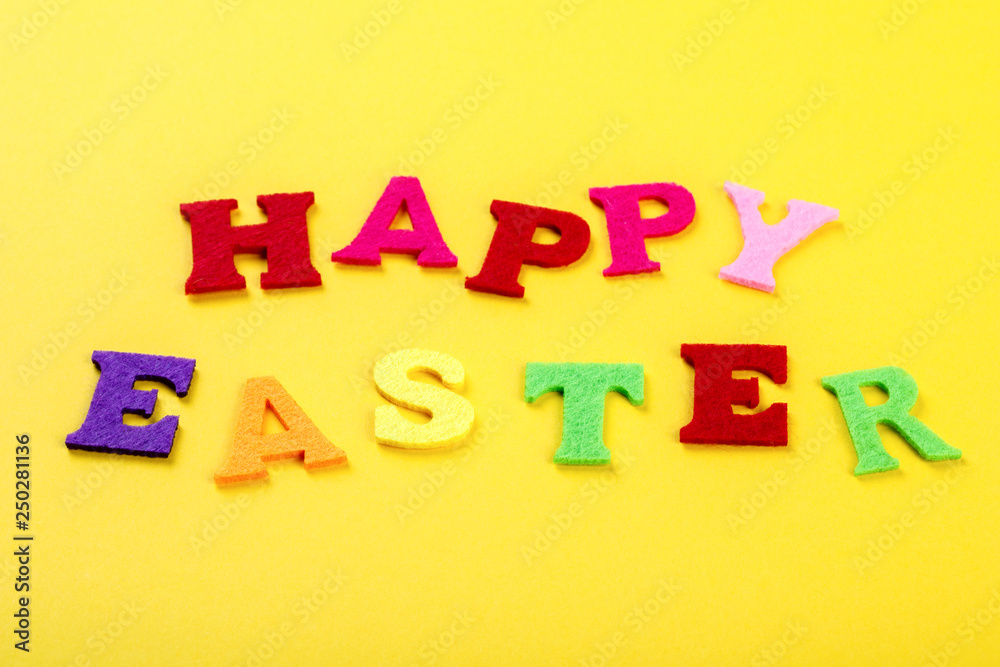 Easter concept. Inscription in colored letters Happy Easter on a yellow background.Top View. Flat Lay.Copy space for Text Easter concept. Inscription in colored letters Happy Easter on a yellow background.Top View. Flat Lay.Copy space for Text