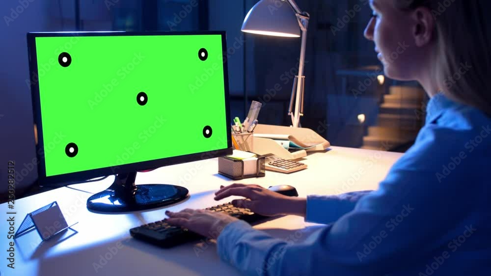 technology, virtual effects and business concept - businesswoman working on computer with chroma key green screen at night office