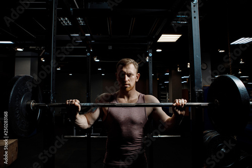 Strong man posing in gym