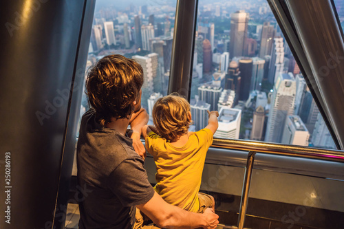 Photography Dad and son are looking at Kuala lumpur cityscape
