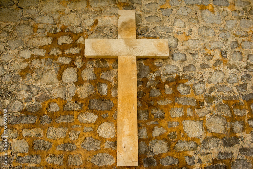 A Christian cross on a stone wall