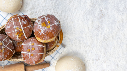 Tasty doughnuts with jam on flour background. Fat Thursday decoration. photo