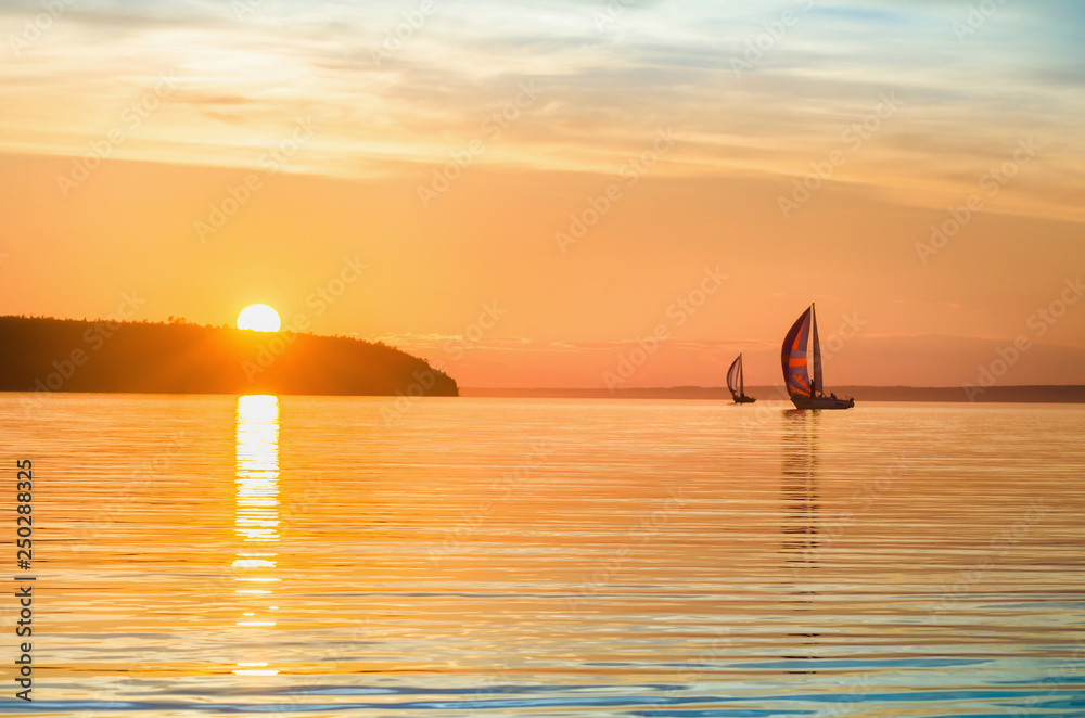Orange with blue sunrise, sunset on the river with sailing yachts.