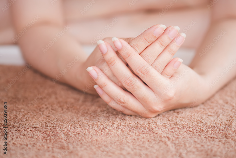 The woman's hand is placed on the towel, the concept of health care of the fingernail.
