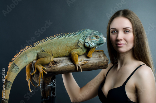 sensual woman and green iguana in studio