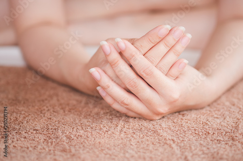 The woman s hand is placed on the towel  the concept of health care of the fingernail.
