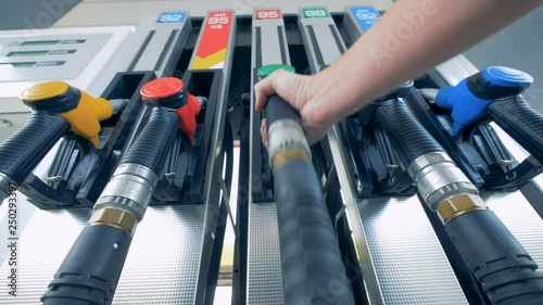 Male hand is putting a green gas pistol back into its pump