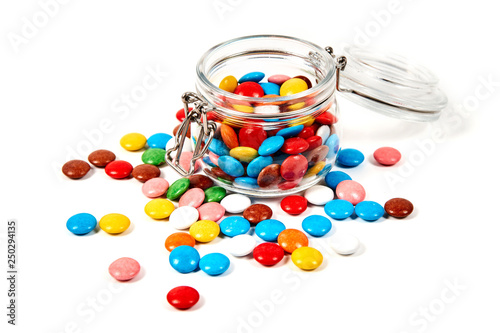 Colorful candies in glass jar isolated on white
