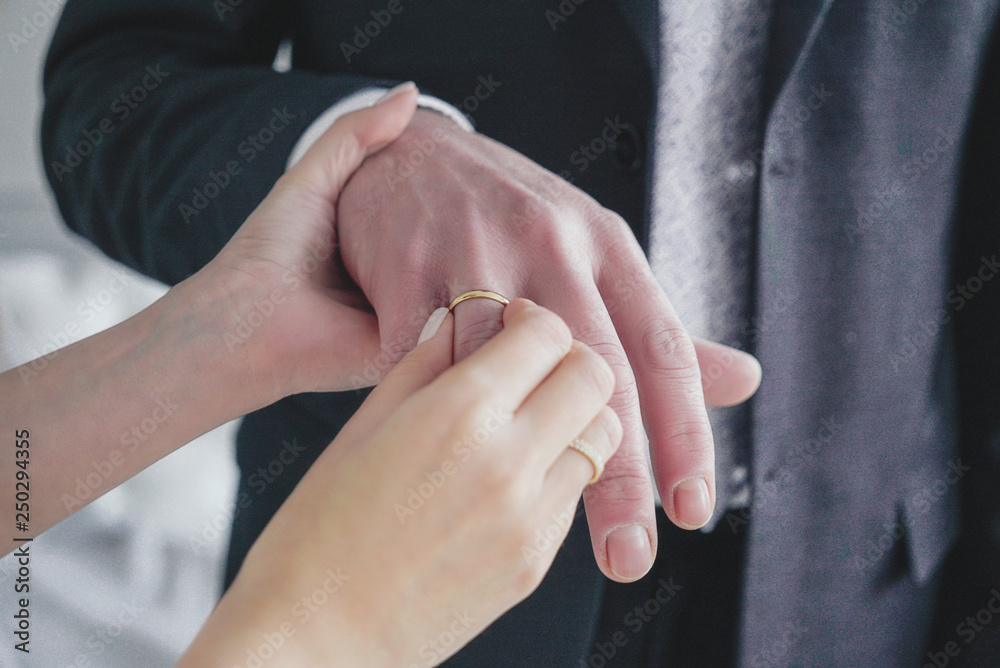 Woman bride puts golden ring on the finger of groom, candid monent of wedding day Woman bride puts golden ring on the finger of groom, candid monent of wedding day
