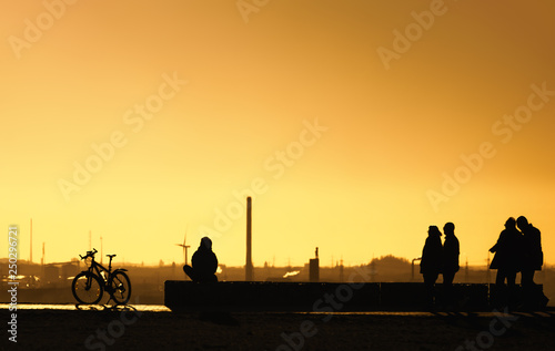 Menschen gehen spazieren bei Sonnenuntergang