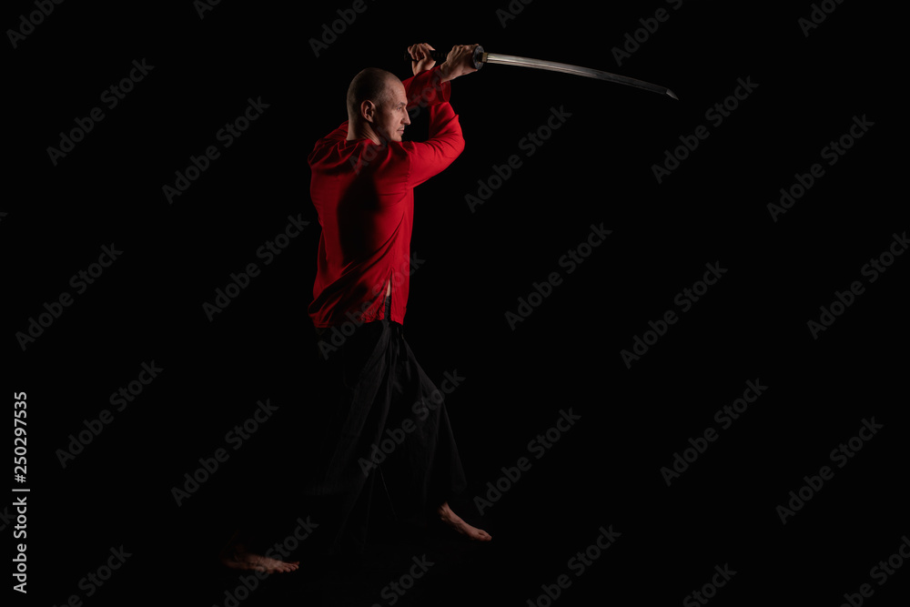Male in red shirt doing exercises with a sword