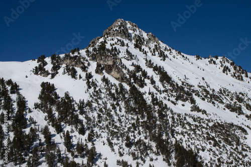 Pic rocheux dans les alpes françaises recouvert de neige en hiver pendant une journée ensoleillée sans nuage