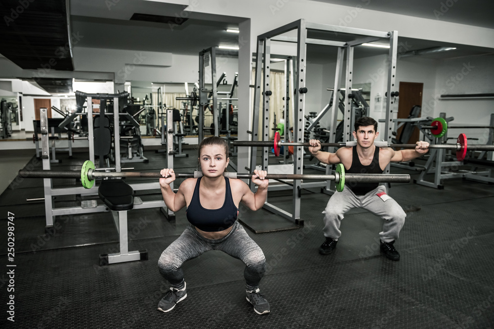 Pair training instructor with woman, both holding dumbbells Pair training instructor with woman, both holding dumbbells