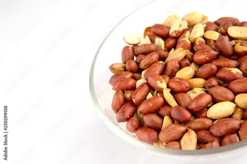 Roasted peanuts in a glass plate isolated on white background Roasted peanuts in a glass plate isolated on white background