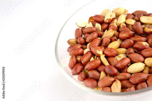 Roasted peanuts in a glass plate isolated on white background
