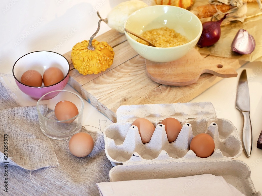 Eggs, pumpkins, sea salt on a light table, top view, home cooking ingredients, shades of yellow