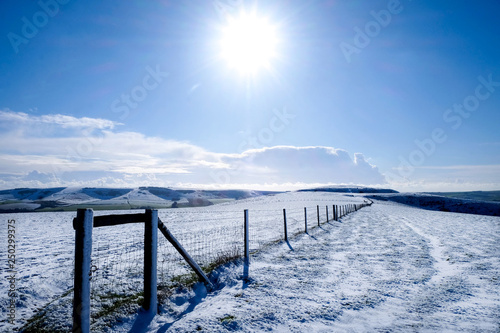 A long fence on the top of a white snow covered mountain