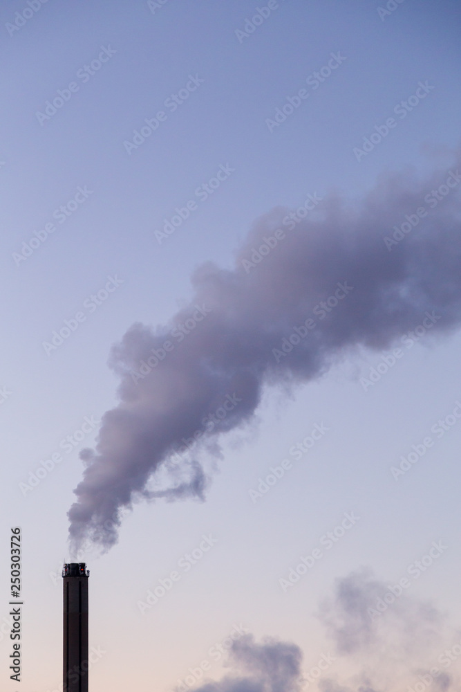 Smoke coming from a heat plant chimney on a cold winter evening Smoke coming from a heat plant chimney on a cold winter evening