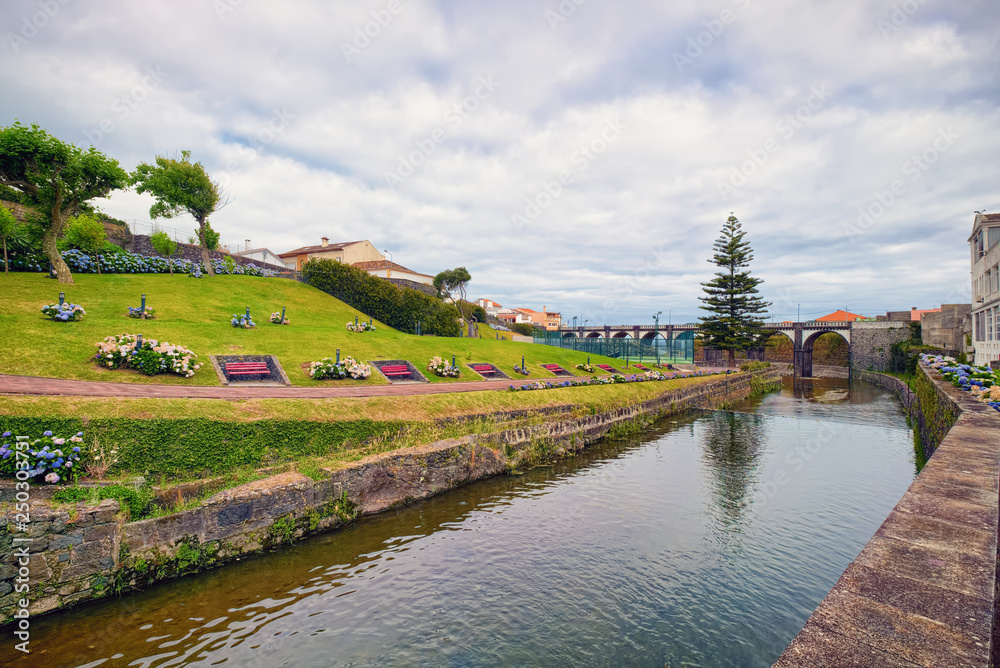 Fototapeta premium River across the municipal park in center of Ribeira Grande town, located on Sao Miguel island of Azores, Portugal.