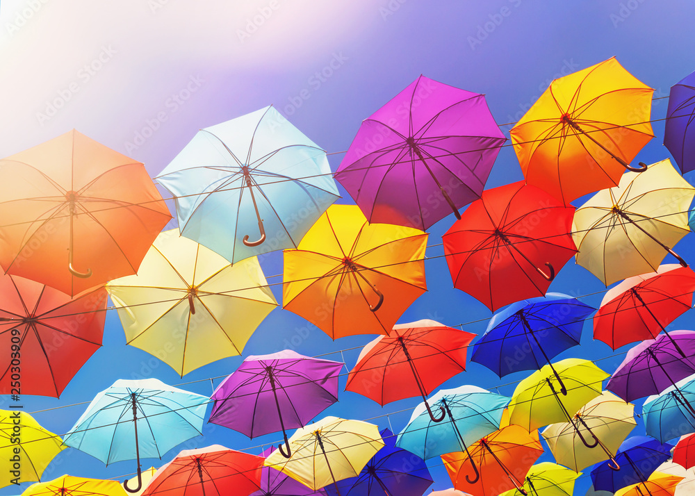 Colorful umbrellas on the sky background, toned.