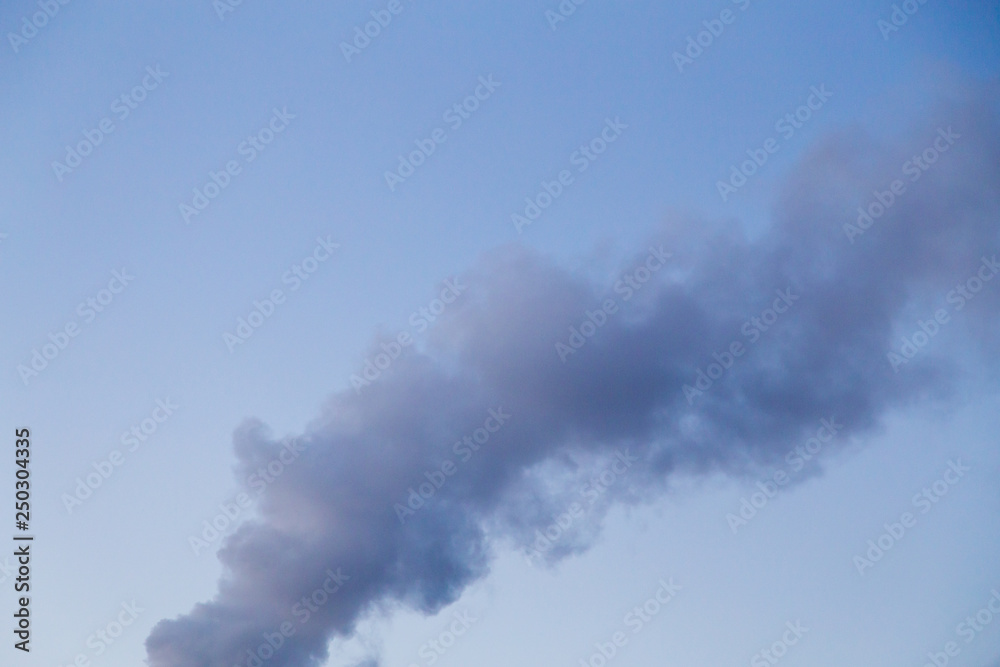 Smoke coming from a heat plant chimney on a cold winter evening