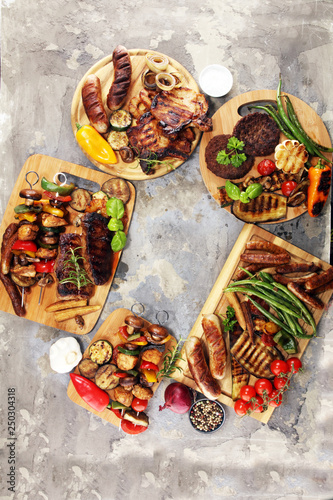 Assorted delicious grilled meat with vegetable on rustic table
