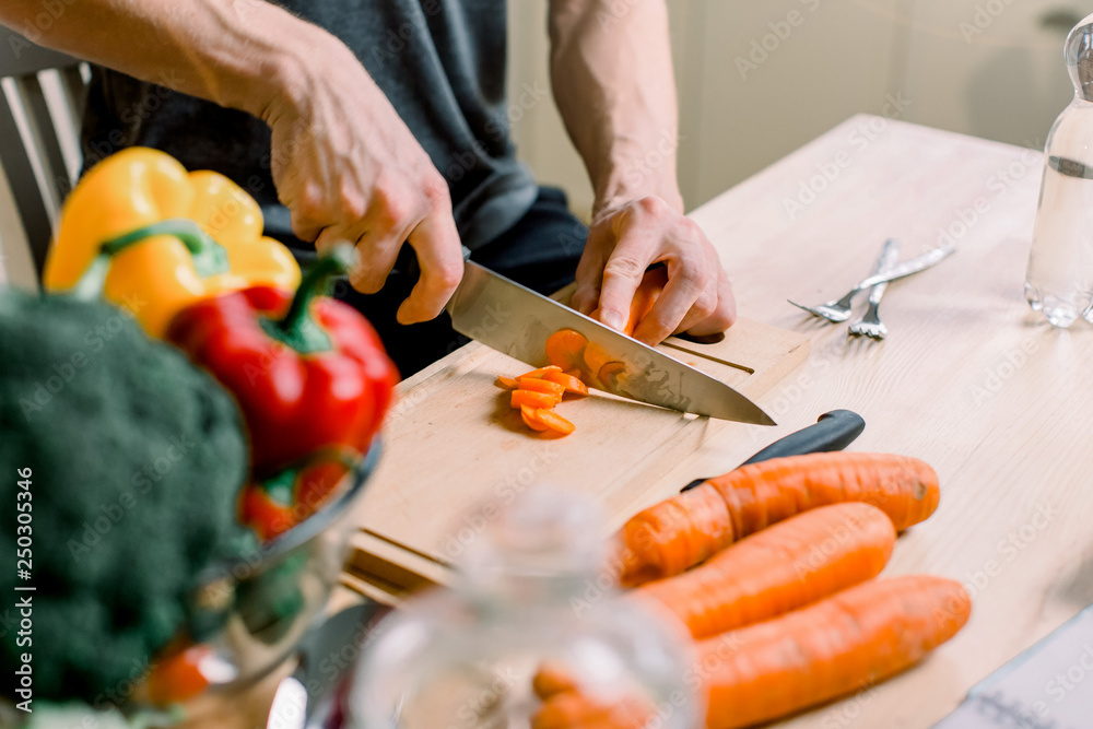 Healthy lifestyle, healthy food. A young man prepares a salad from fresh vegetables and fruits.