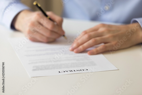 Man signing contract close up hands and document
