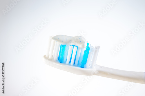 toothbrush with toothpaste on a wigh background  close up