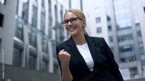 Canvas Print Business woman showing yes gesture, rejoices at promotion and successful career