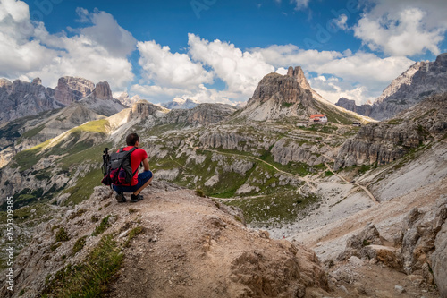 Man traveler hiking alone in breathtaking landscape of Dolomites mountains in summer in Italy.