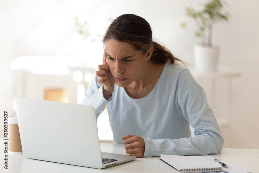 Young woman with poor vision looking at computers screen Young woman with poor vision looking at computers screen