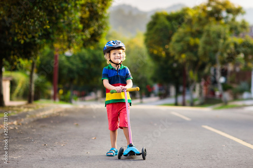 Child on scooter in summer. Kids skate.