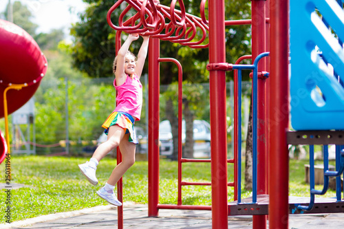 Child on monkey bars. Kid at school playground.