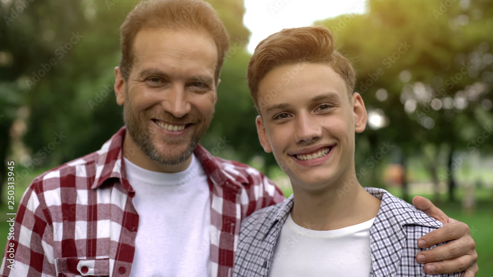 Father and son smiling and looking at camera, teeth health, dentalcare whitening Father and son smiling and looking at camera, teeth health, dentalcare whitening