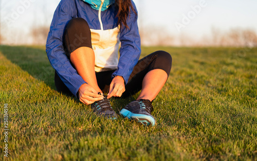 Young woman tying shoelace of sneakers to make outwork training running. Fitness and healthy lifestyle