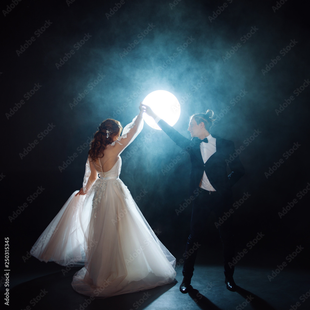Couple dancing, the bride and groom under the moon. Hugs together. Man and woman, wedding dress. Couple dancing, the bride and groom under the moon. Hugs together. Man and woman, wedding dress.