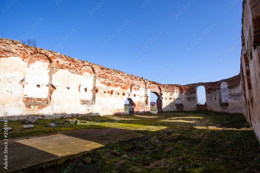 interior, ruined walls and courtyard, overgrown with grass in the ruins of an old medieval red brick building