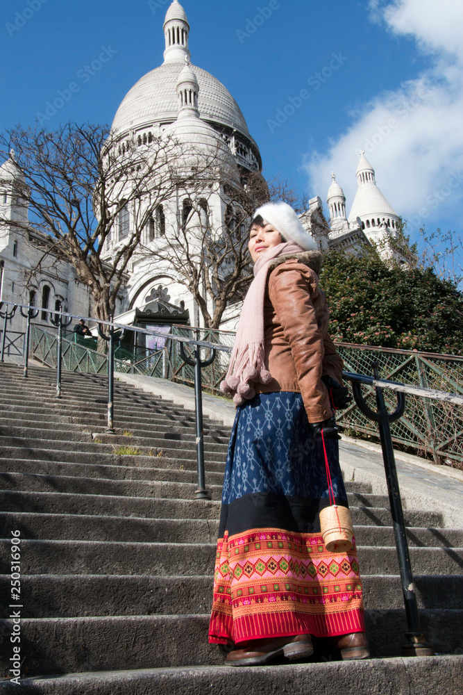 Femme avec  bonnet et écharpe sur les escaliers de la basilique Montmartre à Paris