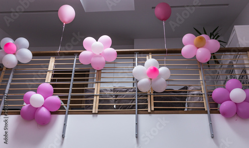 stairs and decorations; stair railings with pink and white balloons and colorful fabric bands photo