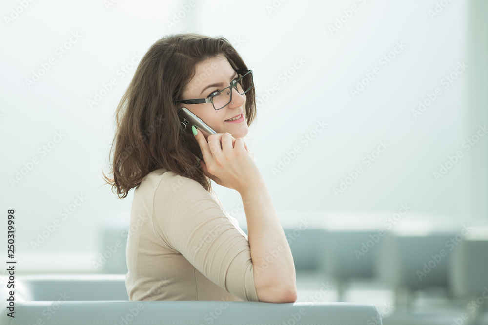 businesswoman talking on a smartphone sitting in the office room businesswoman talking on a smartphone sitting in the office room
