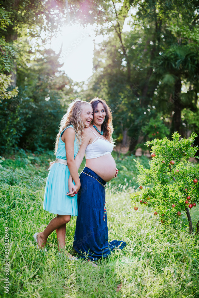 pregnant mother and daughter happy in the field pregnant mother and daughter happy in the field