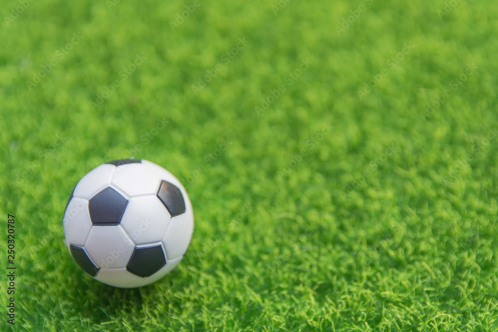 Soccer ball on grass green field with copy space