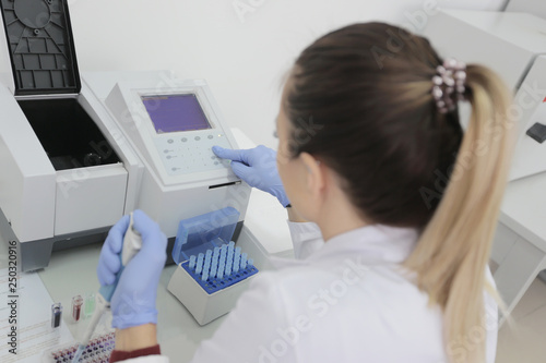 Young female Laboratory scientist working at lab with test tubes and microscope, test or research in clinical laboratory.Science, chemistry, biology, medicine and people concept.