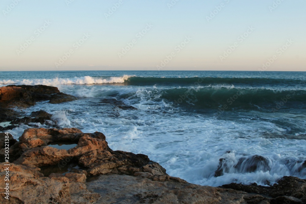 Storm waves on the beach coast summer heat stones sky water Mediterranean Spain