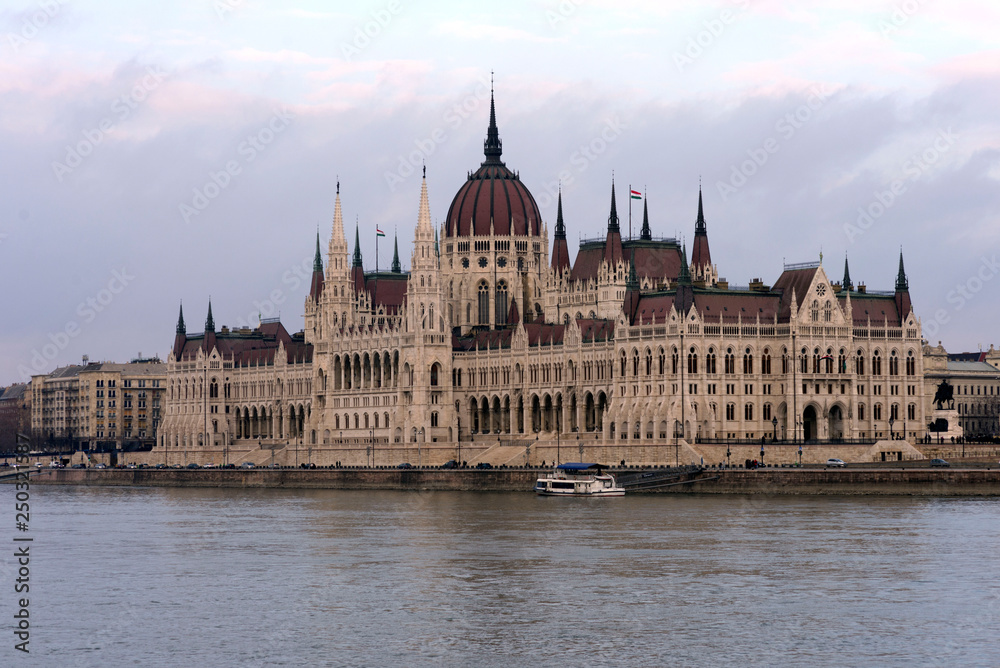 The building of the Hungarian Parliament on the banks of the Danube in Budapest is the main attraction of the Hungarian capital. Beautiful building against the gray sky.