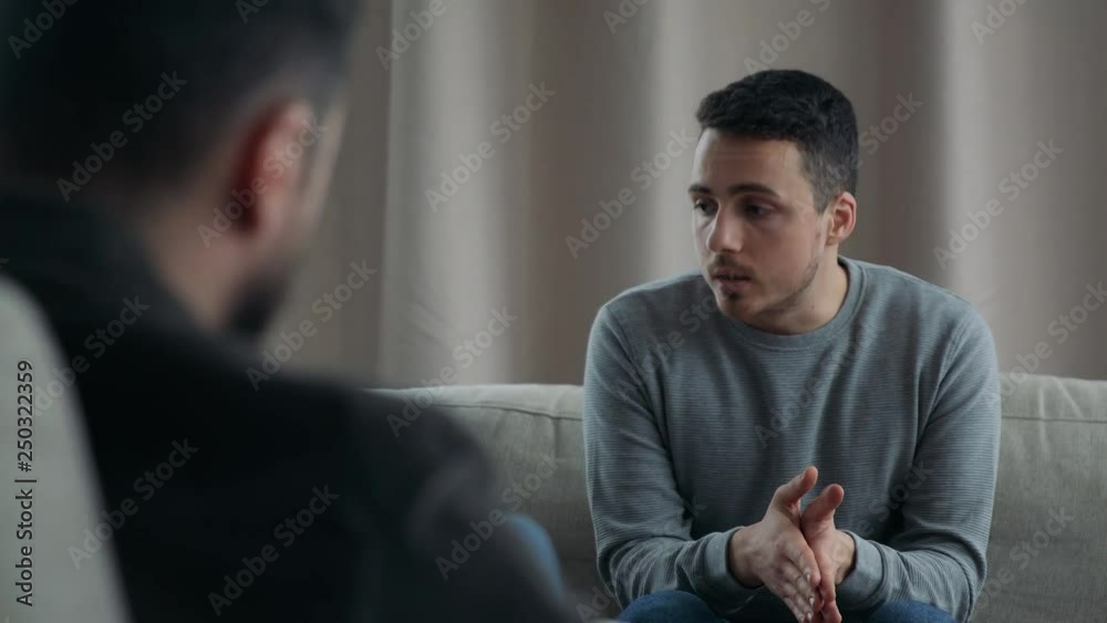 Young man talking to his therapist at therapy session