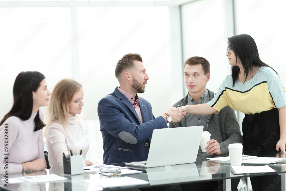 businesswoman shaking hands with the project Manager near the desktop