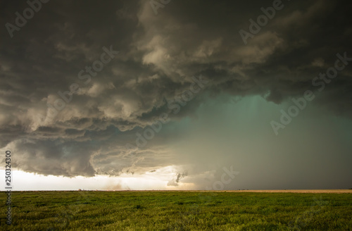 A dangerous supercell storm containing torrential rain and large hail emits a green glow in the sky.