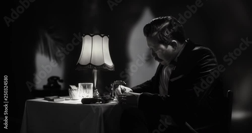 Secret agent writing a letter in a luxury moroccan hotel room, black & white